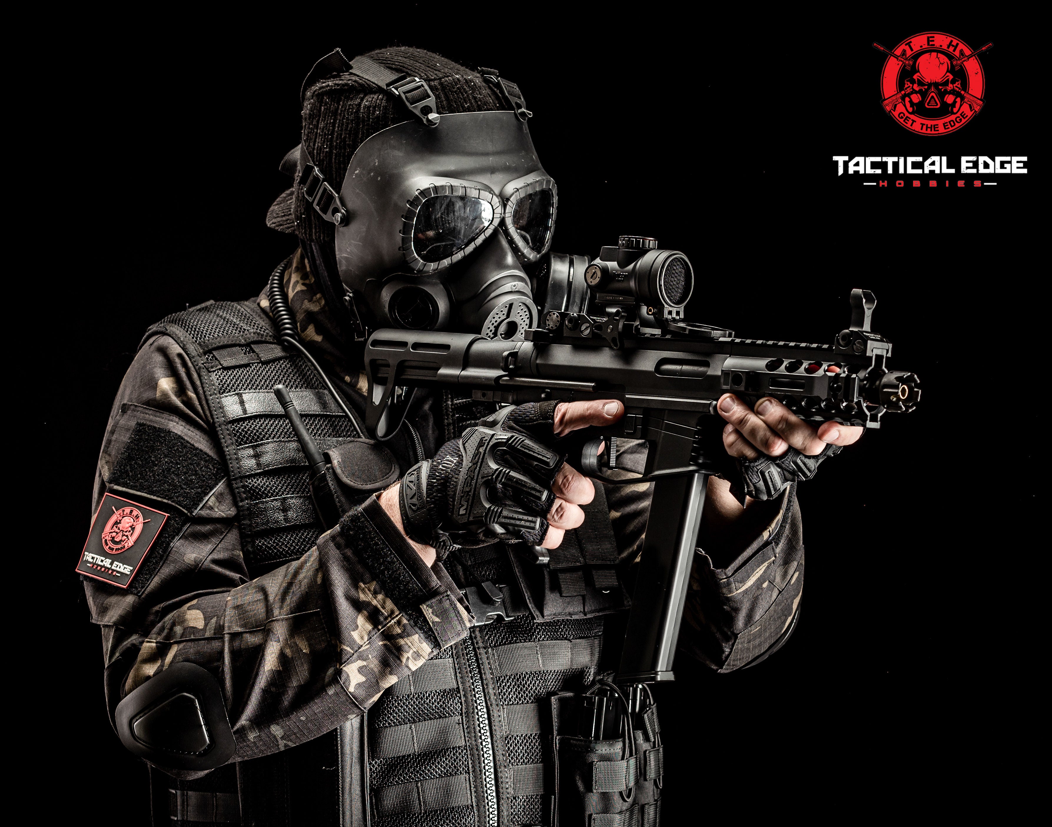 Person in tactical gear holding a gel blaster smg gelsoft electric rifle with 'Tactical Edge' logo in the corner.
